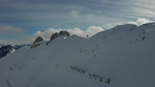 Hikers Traverse Snowy Mountain Ridge on Winter Day