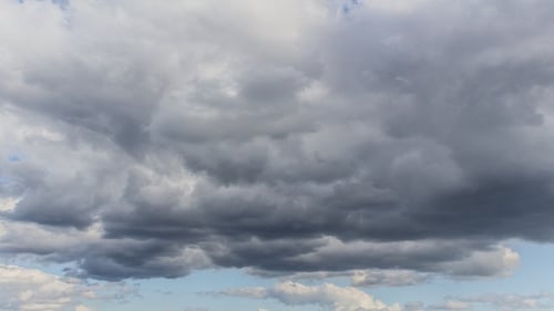 Ominous Gray Clouds Drifting Across Blue Sky