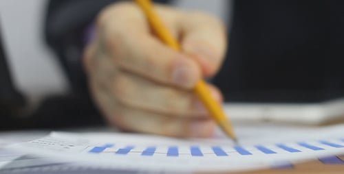 Businessman Works with Sales Chart and Uses Laptop