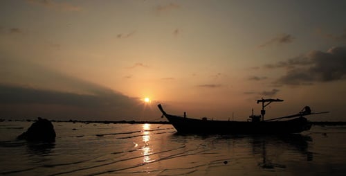 Boat Silhouette on Beach at Golden Sunset