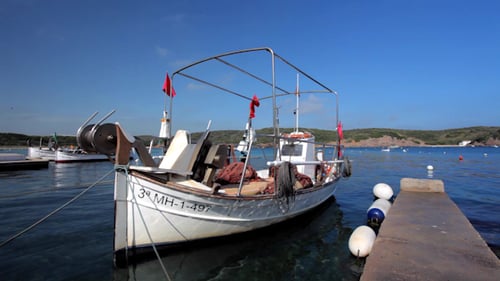 Fishing Boat Docked at Concrete Pier on Sunny Day