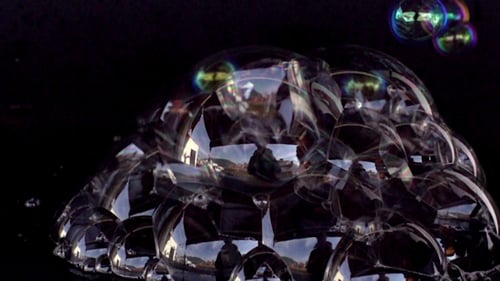 Cluster of Iridescent Soap Bubbles Against Black Background