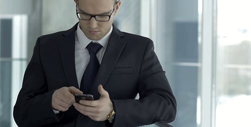 Young Adult in Suit Using Smartphone Indoors