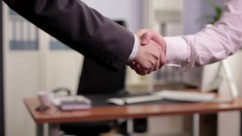 Business Handshake Agreement in Modern Office