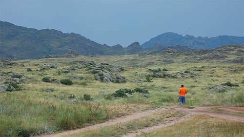 Man Photographing Mountain Landscape on a Cloudy Day
