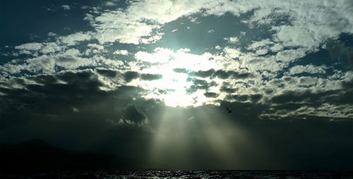 Dramatic Sun Rays Breaking Through Clouds Over Ocean