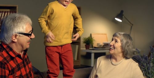 Child Climbing on Couch Between Grandparents