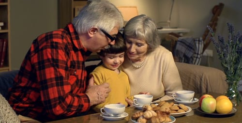 Child Enjoying Tea with Grandparents at Home
