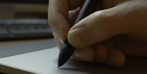 Hand Using Stylus on Digital Tablet Close-Up