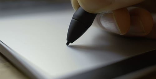 Hand Uses Stylus on Tablet Device Close Up