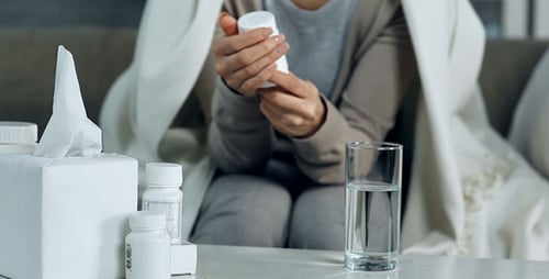 Woman Takes Pills with Water at Home