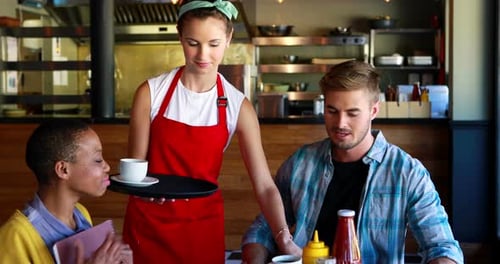 Waitress serving coffee to customers