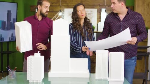 Architects Discussing Building Model in Bright Workplace