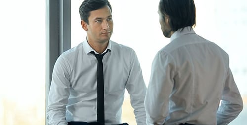 Two Businessmen Talking Over Coffee in Office