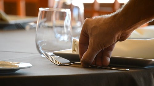 Eine Gabel in einen Restauranttisch setzen