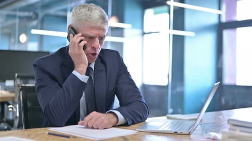 Businessman Arguing On Phone in Modern Office
