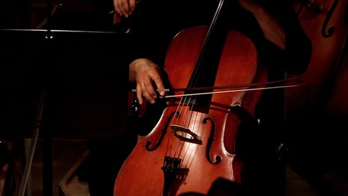 Cellist Playing Cello in Dark Room