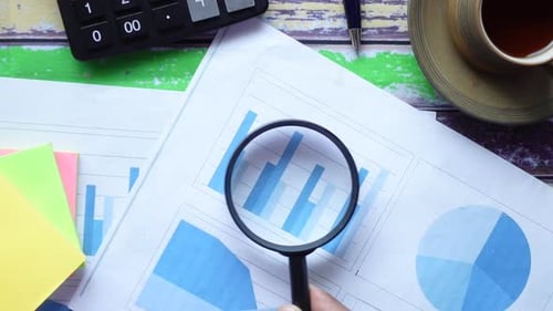 Open Book and Magnifying Glass on Table