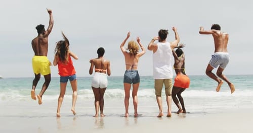 Group of mixed-race friends dancing together on the beach 4k