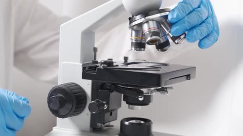 Scientist Adjusting Microscope in Medical Lab, Close Up