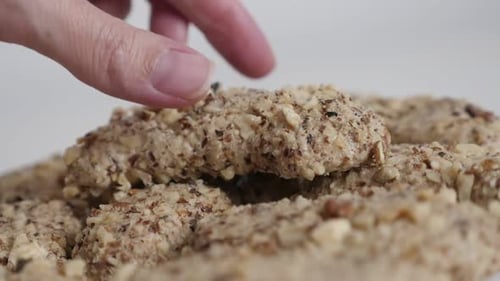 Hand Picks a Nut-covered Cookie