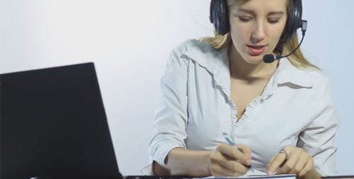 Call Center Operator Makes Notes While Working