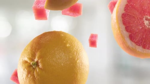 Pomelo con rodajas cayendo sobre fondo de cocina