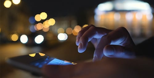 Hands Using Smartphone at Night in City