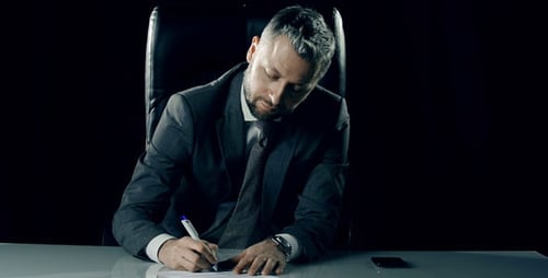 Businessman Signing Document in Dark Office