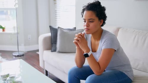 Woman Sitting on Couch in Living Room Thinking