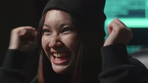 Gros plan d'une hacker asiatique utilisant le piratage informatique et célébrant