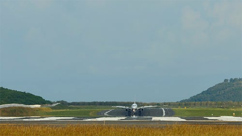 Airplane Landing on Airport Runway During Daytime