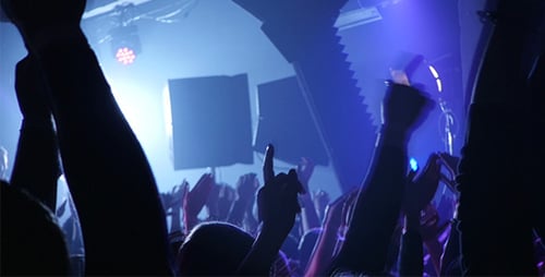 Silhouetted Crowd Celebrates in Dark Venue With Lights