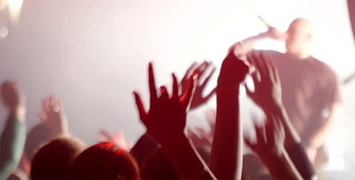 Energetic Crowd at Music Concert Waving Arms