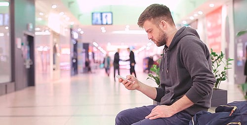 Young Adult Using Smartphone in Shopping Mall