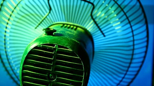 Household Fan Spinning in Blue Green Light