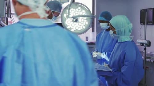 Seitenansicht eines kaukasischen Chirurgen bei der Operation im Operationssaal
