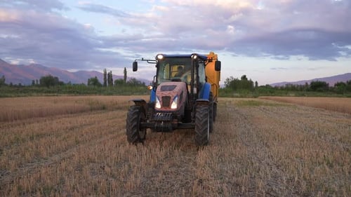 Blue Tractor in Rural Field at Sunset