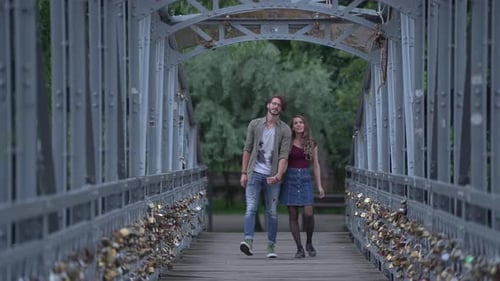 Jeune couple marchant sur un pont