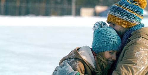 Happy Couple Playfully Embrace on Snowy Winter Day