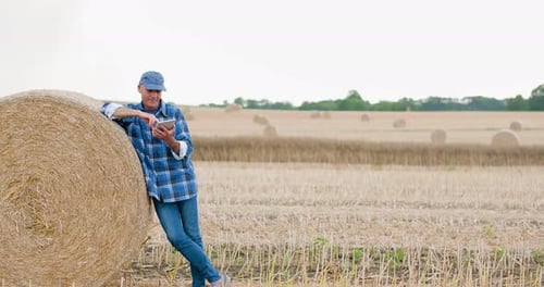 Farmer Using Digital Tablet While Examining Farm