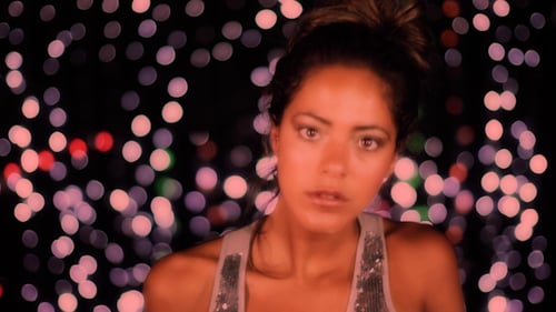 Woman Dancing Expressively With Blurred Lights Background