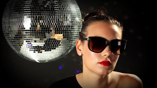 Stylish Woman Dancing with Disco Ball in Studio