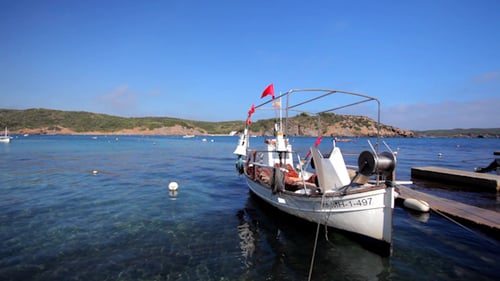 White Boat Docked on Beautiful Blue Water Coast