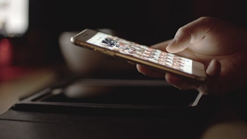 Hand Using a Mobile Phone in the Dark