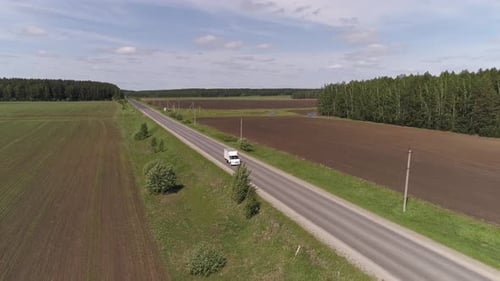 Aerial view of white Delivery truck driving on a straight asphalt road 04