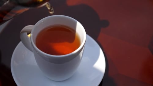 Pouring Black Tea In The Cup Outdoor