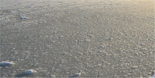 Frozen Lake Covered in Ice and Snow at Sunset