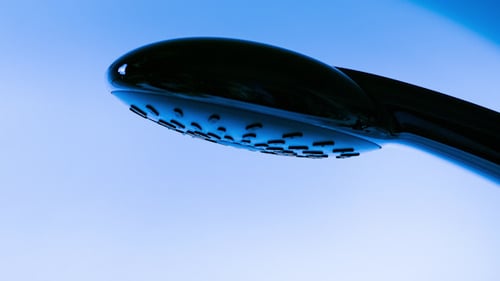 Shower Head Sprays Clear Water in Bathroom
