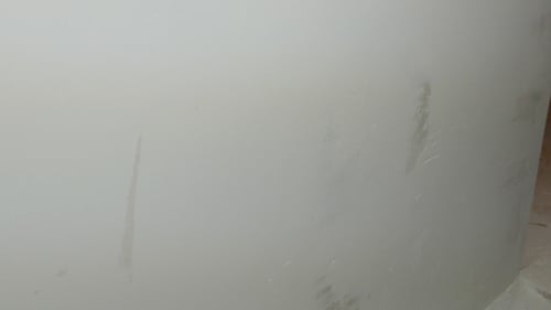 Hand Applying White Filler to Wall with Tool